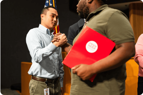 A graduate shaking hands and receiving a certificate
